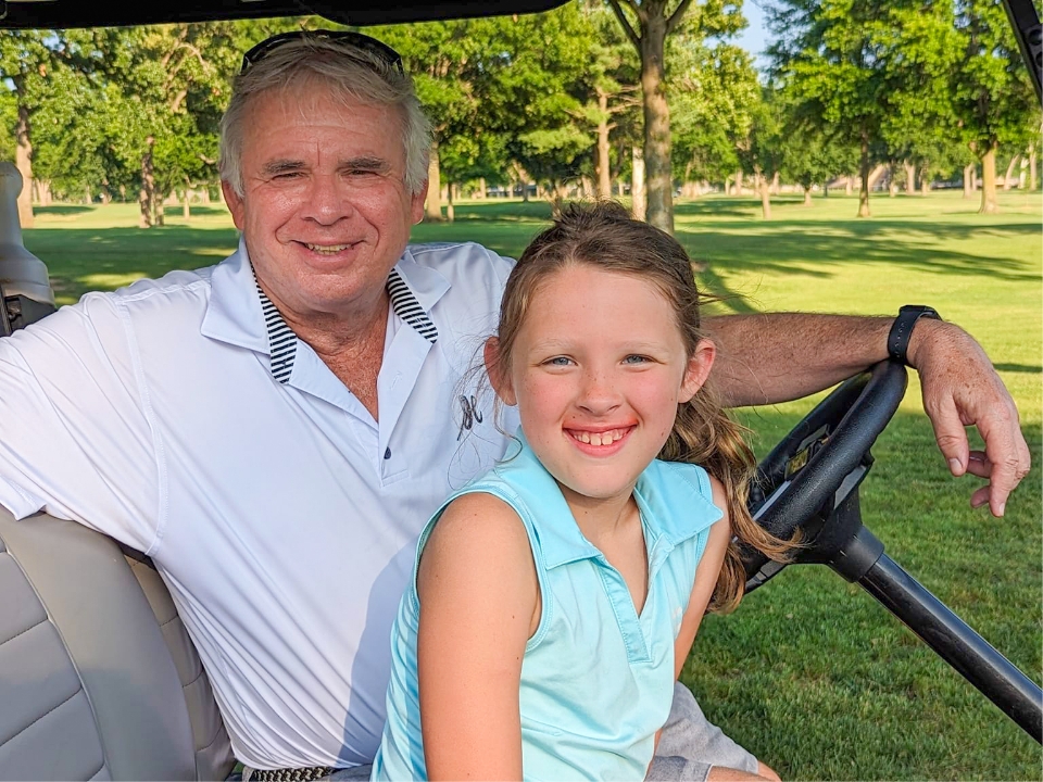 Father and child high-fiving on the golf course