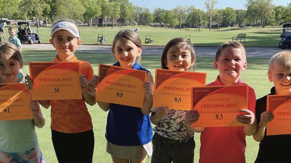 Father and child high-fiving on the golf course